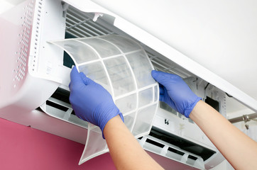 Air conditioner cleaning. Man checks the filter.