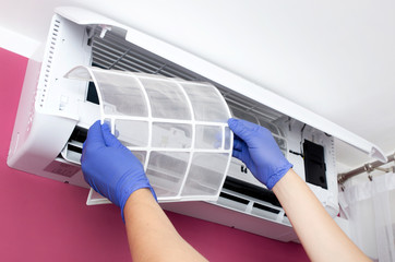 Air conditioner cleaning. Man checks the filter.