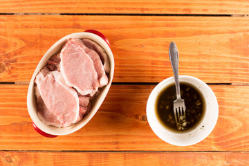 Flat lay top view of fresh pork chops with barbecue marinade in