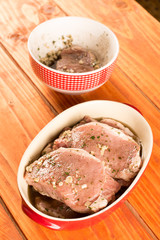 Raw pork chops marinated with barbecue sauce .