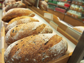 bread and buns in on shelf in bakery or baker's shop