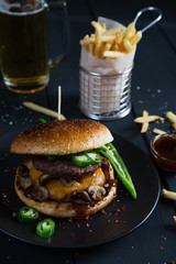 Cheeseburger with jalapeno pepper, French fries and beer