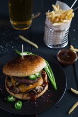 Cheeseburger with jalapeno pepper, French fries and beer