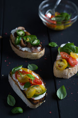 Bruschetta with cherry tomatoes, cream cheese, mushrooms, basil