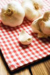 cloves of garlic with vintage red dishtowel in rustic style 