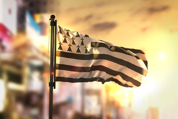 Brittany Flag Against City Blurred Background At Sunrise Backlight