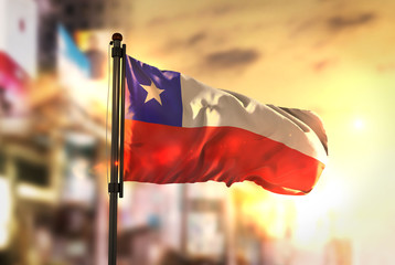 Chile Flag Against City Blurred Background At Sunrise Backlight