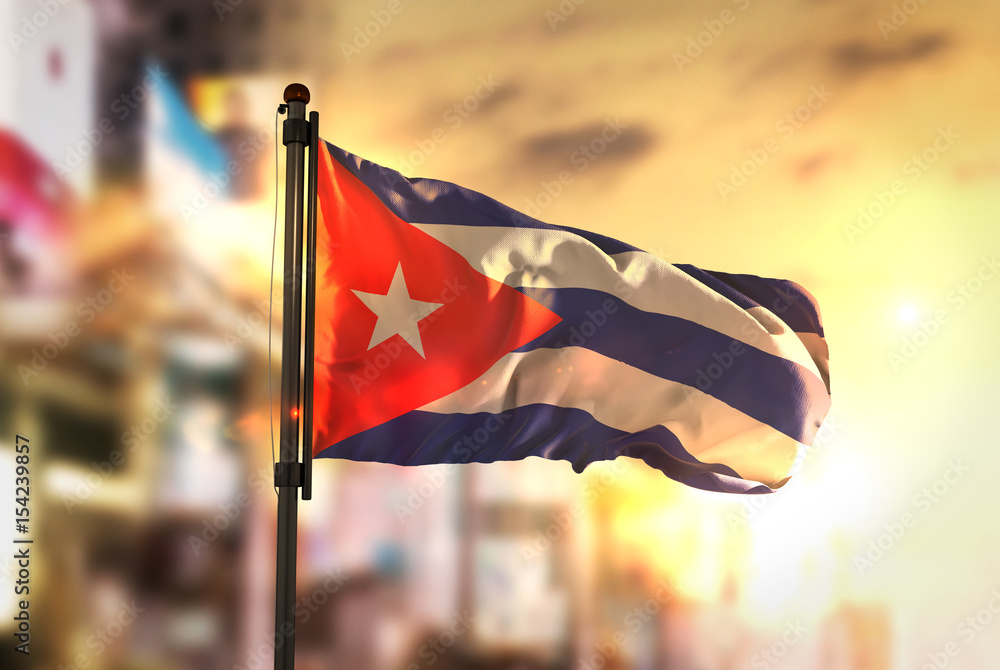 Wall mural Cuba Flag Against City Blurred Background At Sunrise Backlight