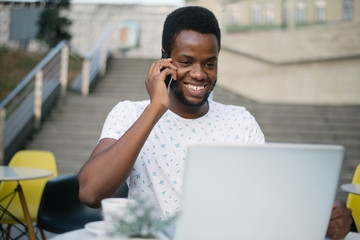 Handsome Afro American businessman in casual clothes with laptop
