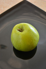 ripe green Apple on black glossy background