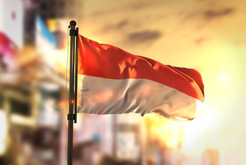 Indonesia Flag Against City Blurred Background At Sunrise Backlight