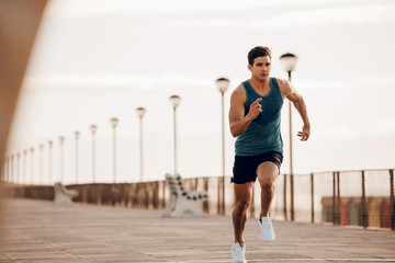 Male runner sprinting outdoors in morning