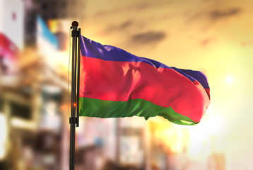 Kuban People's Republic Flag Against City Blurred Background At Sunrise Backlight