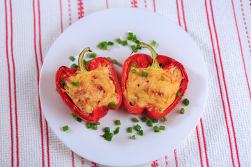 The stuffed red pepper strewed with cheese and decorated with greens
