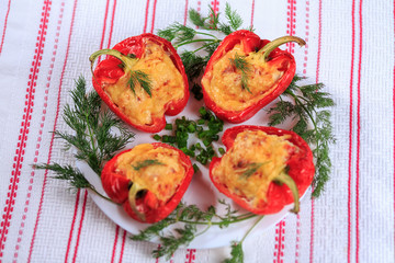 The stuffed red pepper strewed with cheese and decorated with greens