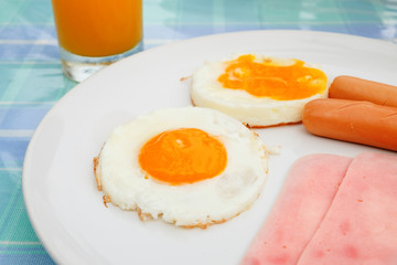 Side view close up, double egg with sausage on white plate for breakfast