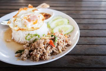 side view rice topped with stir-fried pork and basil topping with sunny up fired egg