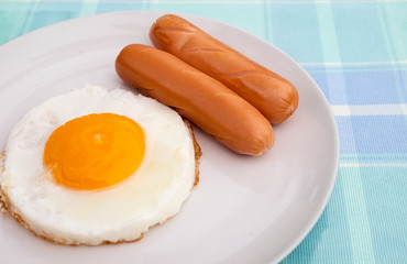 Side view close up, double egg with sausage on white plate for breakfast