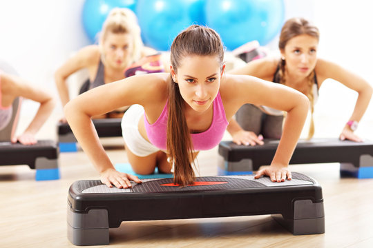Group of smiling people doing push-ups