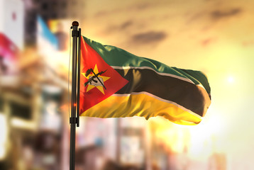 Mozambique Flag Against City Blurred Background At Sunrise Backlight © natanaelginting
