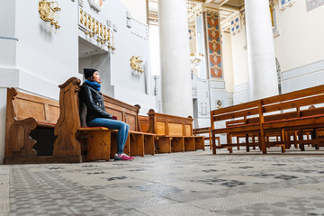 Young faithful woman praying in the church
