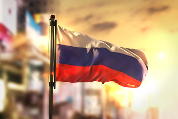Russia Flag Against City Blurred Background At Sunrise Backlight