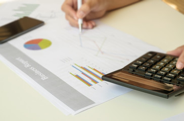 blurred accountant checking finance report and using calculator