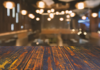 Vintage wooden surface top view with blurred restaurant background.