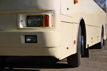 Photo of the hull of a large and long yellow bus. Close-up front view of a passenger vehicle for...