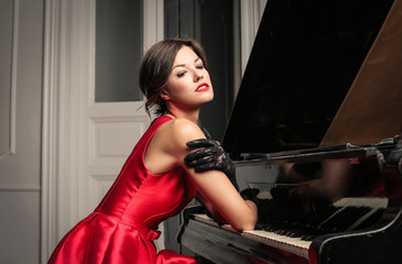 Fototapeta na wymiar Sensual woman playing piano