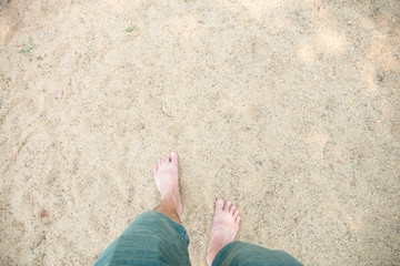 man's feet on sand