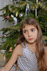 junges Mädchen vor dem Christbaum