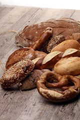 Different kinds of bread and bread rolls on board from above. Kitchen or bakery poster design.