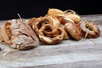Different kinds of bread and bread rolls on board from above. Kitchen or bakery poster design.