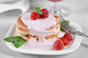 Delicious pancakes with raspberries and yogurt on plate