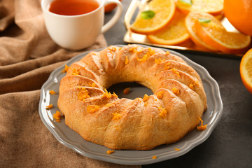 Appetizing citrus cake with orange zest on grey plate