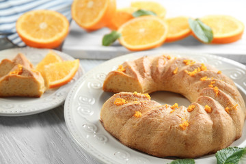 Appetizing citrus cake with orange zest on white plate
