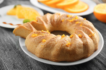 Appetizing citrus cake with orange zest on grey table