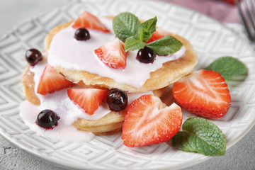 Delicious pancakes with berries and yogurt on plate