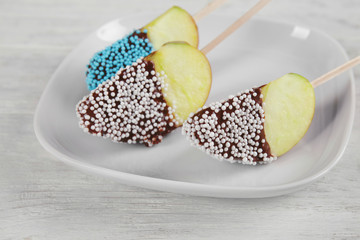 Plate with candied apple wedges on sticks