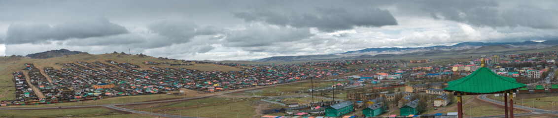 view of city on hills with mountains on background at cloudy day
