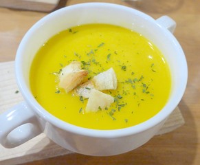Tasty pumpkin soup with bread close up 