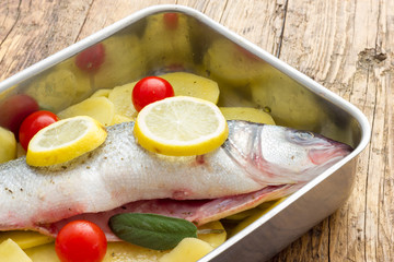 Fish with lemon potatoes and tomatoes ready for the oven