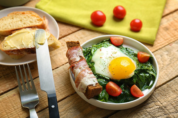 Delicious eggs Florentine with tomatoes on kitchen table