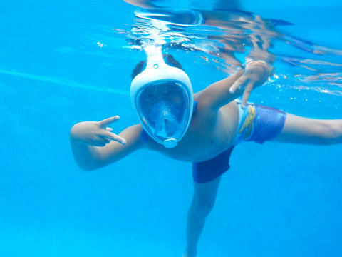 El chico nadando en la piscina con Easybreath mask.. puedes nadar, puedes busear, puedes respirar abajo del agua..