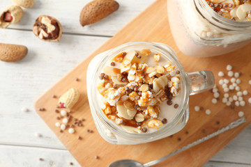 Delicious parfait with granola in jar on board