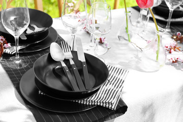 Plates with cutlery on served festive table