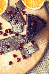 Chocolate cake with pomegranate seeds on a wooden table