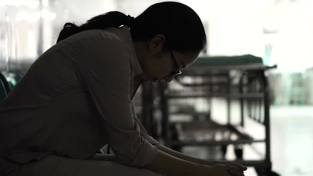 Asian woman sitting alone in hospital. Worried and  anxious from thinking of bad news 4K