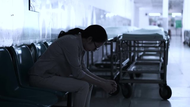Asian woman sitting alone in hospital. Worried and  anxious from thinking of bad news 4K